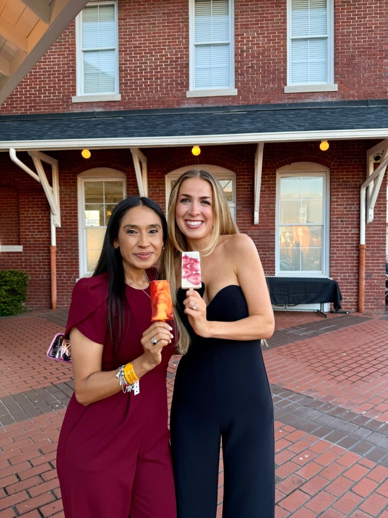 Two women at a formal event holding La Michoacana paletas — Gainesville GA